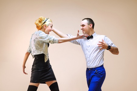 Cute adult girl and boy simulating funny battle,  backgroundの写真素材