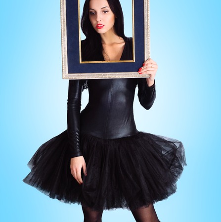 Woman wearing in black dress holding picture frame.の写真素材