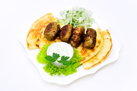 Meatball on pita with sauce and cucumber saladの写真素材
