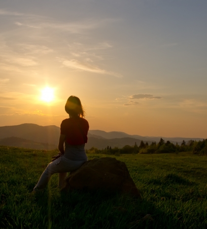 woman silhouette in the mountain at sunsetの写真素材