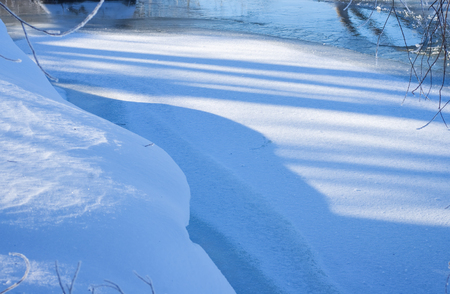 Snow on shore of riverの写真素材