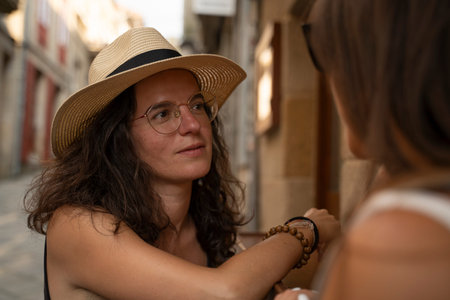 two women chatting and laughing outside a bar in Spain