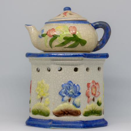 A particular ceramic candlestick made of three pieces. Floral-themed work in blue, red, yellow colors.の写真素材