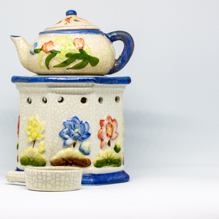 A particular ceramic candlestick made of three pieces. Floral-themed work in blue, red, yellow colors.の写真素材