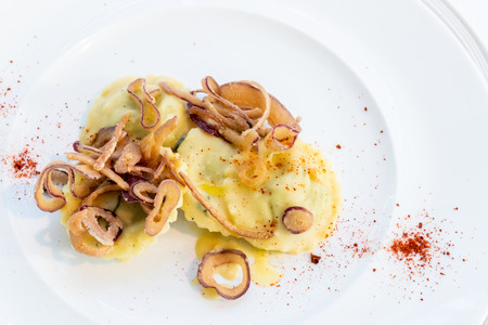 First dish for a wedding. Ravioli stuffed with ricotta and broad beans served with fried onion and red pepper.の写真素材