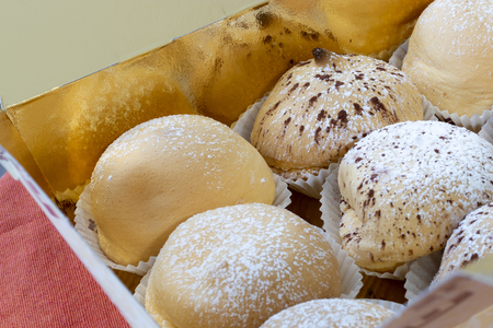 Sunday sweets. A tray with Italian regional specialties of small pastries with cream and chocolate desserts.の写真素材