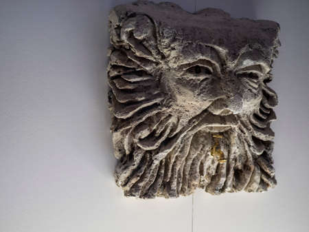 Bari, Italy - 12 15 2019: A day with the family in the Christmas village of Bari, a city in southern Italy. A Gothic sculpture of a man's face and a tap comes out of his lips.のeditorial素材