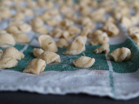 Dinner time at home with the family. On a tablecloth numerous orecchiette, a typical product of southern Italian cuisine.の写真素材