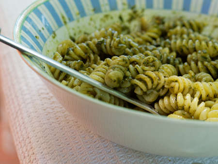 A typical Italian dish with pasta with pesto, a sauce made with basil, parmesan and olive oil.の写真素材