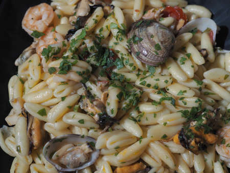 Lunchtime with a typical Italian dish based on fish. A first course of pasta with mussels, clams, squid, parsley and olive oil.の写真素材