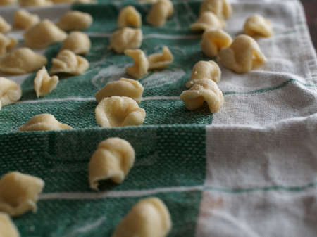 Dinner time at home with the family. On a tablecloth numerous orecchiette, a typical product of southern Italian cuisine.の写真素材