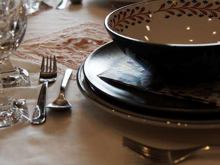 Lunch time at home with relatives and friends. A ceramic plate and cutlery on the table waiting for the guests.の写真素材