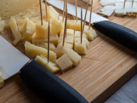 Prepare an appetizer to serve for dinner time at home. A typical cheese of Italian cuisine cut into small squares.の写真素材