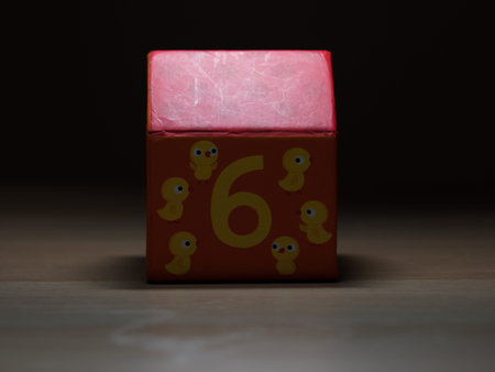 Children's toys around the house. A small paper house numbered with the design of six chicks.