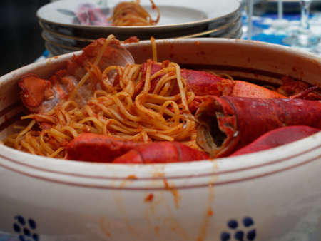 A dinner at home to celebrate a special occasion. A first course of Italian cuisine based on fish with pasta and lobster.の写真素材