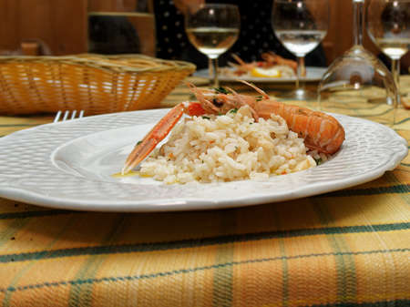 A dinner for a birthday party in an Italian restaurant. A first course with rice and shrimp served on a white plate.の写真素材