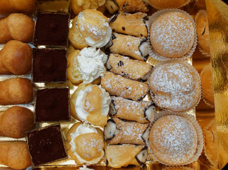 One of the most anticipated moments during a lunch in Italy. At the end of the meal, small pastries arrive served on a golden paper tray.の写真素材