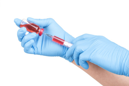 Test tubes with blood in hand isolated on whiteの写真素材