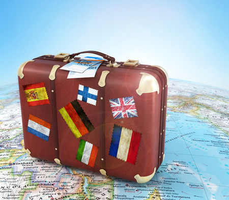 old suitcase with air ticket and striples flags on blurred world map and sky in backgroundの写真素材