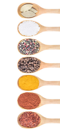 Collection of 7 spices on a wooden spoon. isolated on a white background の写真素材