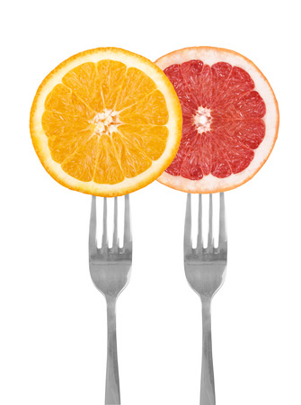 citrus fruit on forks, orange, grapefruit, isolated against whiteの写真素材