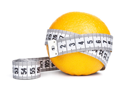 Orange fruit with tape measure on white backgroundの写真素材
