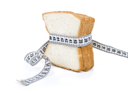 Piece of bread grasped by measuring tapeの写真素材