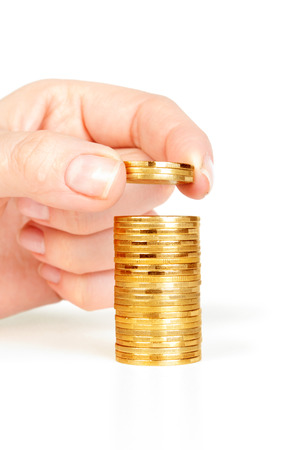 coins in finger and row stacks them isolated on whiteの写真素材