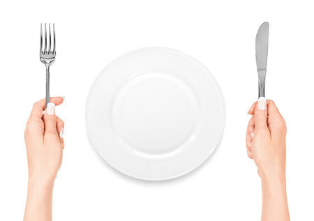 hand holding fork and knife with plate isolated on white backgroundの写真素材