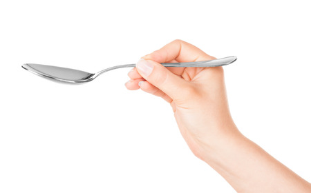 Spoon in hand on white backgroundの写真素材