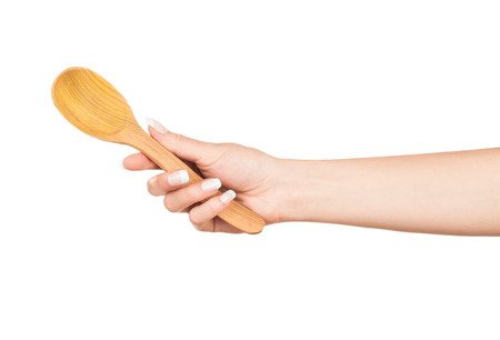 Woman hand with wooden spoon isolated on white backgroundの写真素材