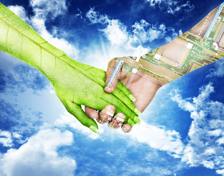 Nature and electronics holding hands in sky backgroundの写真素材