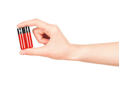 hand holds a red AA battery on an isolated white backgroundの写真素材