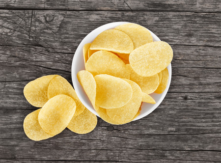chips in a plate on a wooden backgroundの写真素材