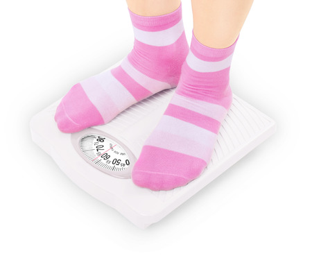 Feet on scales isolated on whiteの写真素材