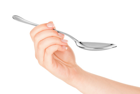 Spoon in hand on white backgroundの写真素材