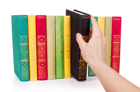 Hand picking book in libraryの写真素材