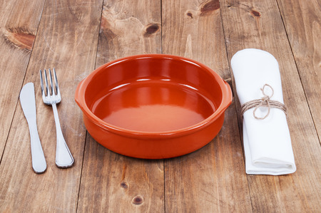 plate, knife and fork at napkin on wooden backgroundの写真素材