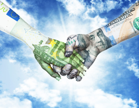euro and dollar holding hands in sky backgroundの写真素材