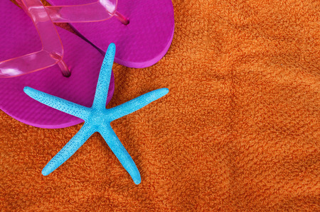 Beach themed starfish on flip flops and beach towelの写真素材