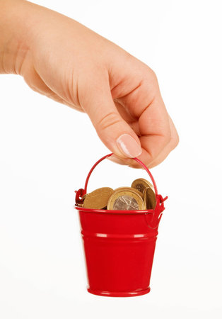Bucket of money in hand on a white backgroundの写真素材