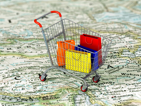 International shopping. Colorful package in the shopping cart on the world map. World trade concept.の写真素材