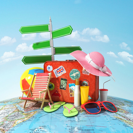 Recreation and travel concept. Road sign old suitcase for travel beach hat beach ball sunglasses sun cream and beach shoes on the world map and blue sky. Direction to recreation.の写真素材
