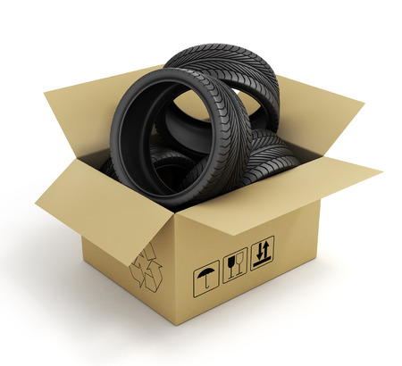 Open Cardboard Box with Tires on white background. Online store of auto parts.の写真素材
