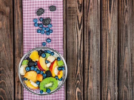 fresh fruit salad in the plate on the fabric photographed on a dark wooden backgroundの写真素材