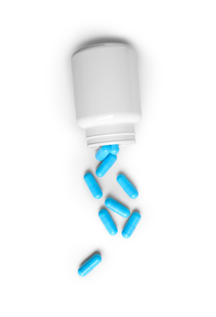 Open a bottle of spilled pills. Isolated on whiteの写真素材