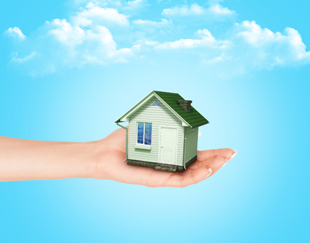 The house in hands on blue skyの写真素材