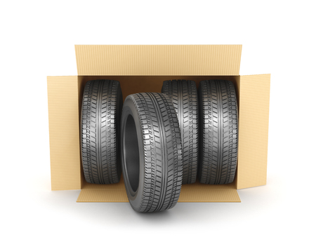 Stack of four new wheels in an open cardboard box isolated on white backgroundの写真素材