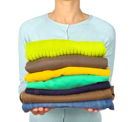 Woman hold clothes pile against white background, close upの写真素材