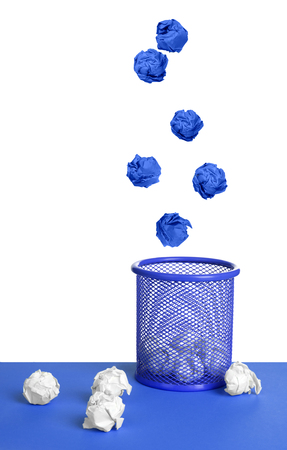 isolated wastebasket full of waste paper and fly ballの写真素材